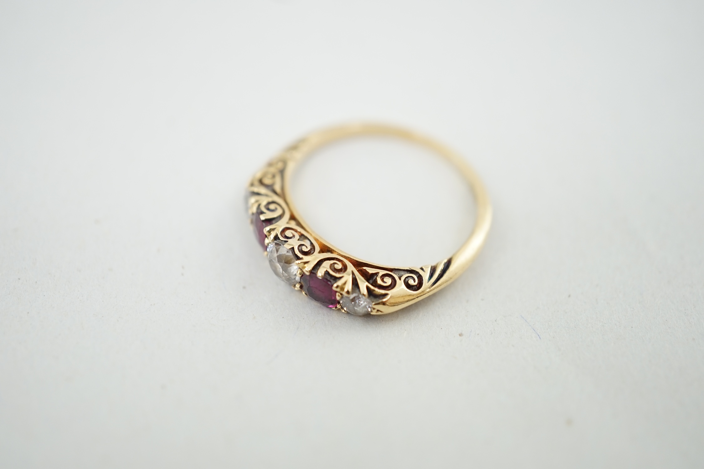 A late Victorian gold, three stone diamond and two stone ruby set half hoop ring